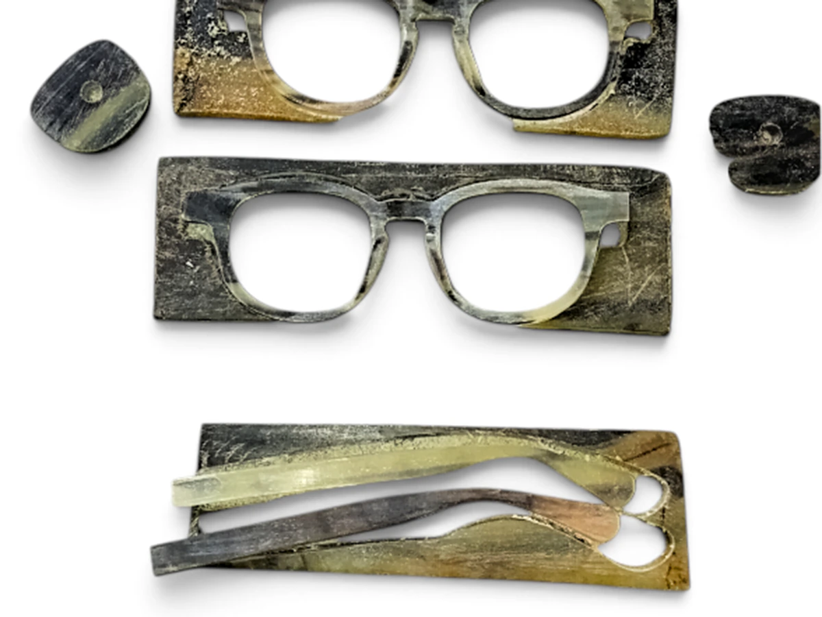 Semi-finished horn fronts and temple blanks showing thickness, grain variation and early frame shaping