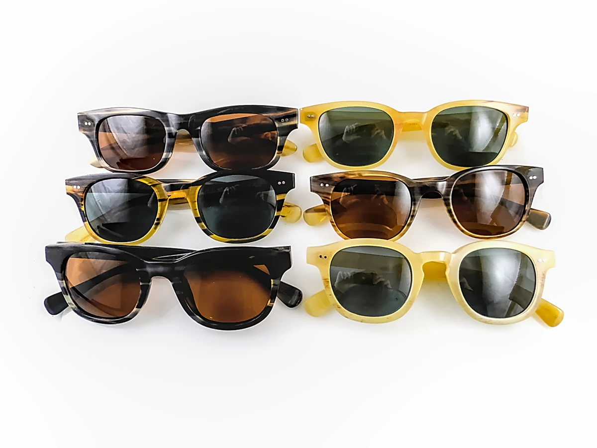 Custom buffalo horn eyewear in varied natural tones and grain patterns, shown across six finished sunglasses frames