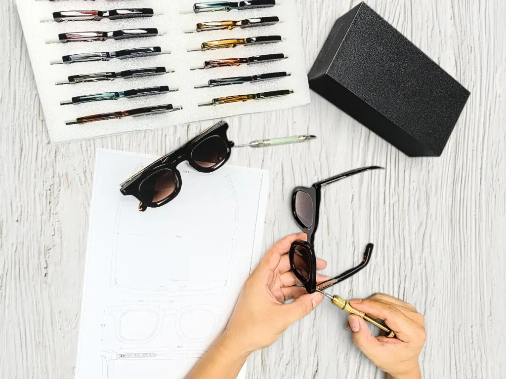 Sunglasses samples, frame components and a technical drawing reviewed during custom product development