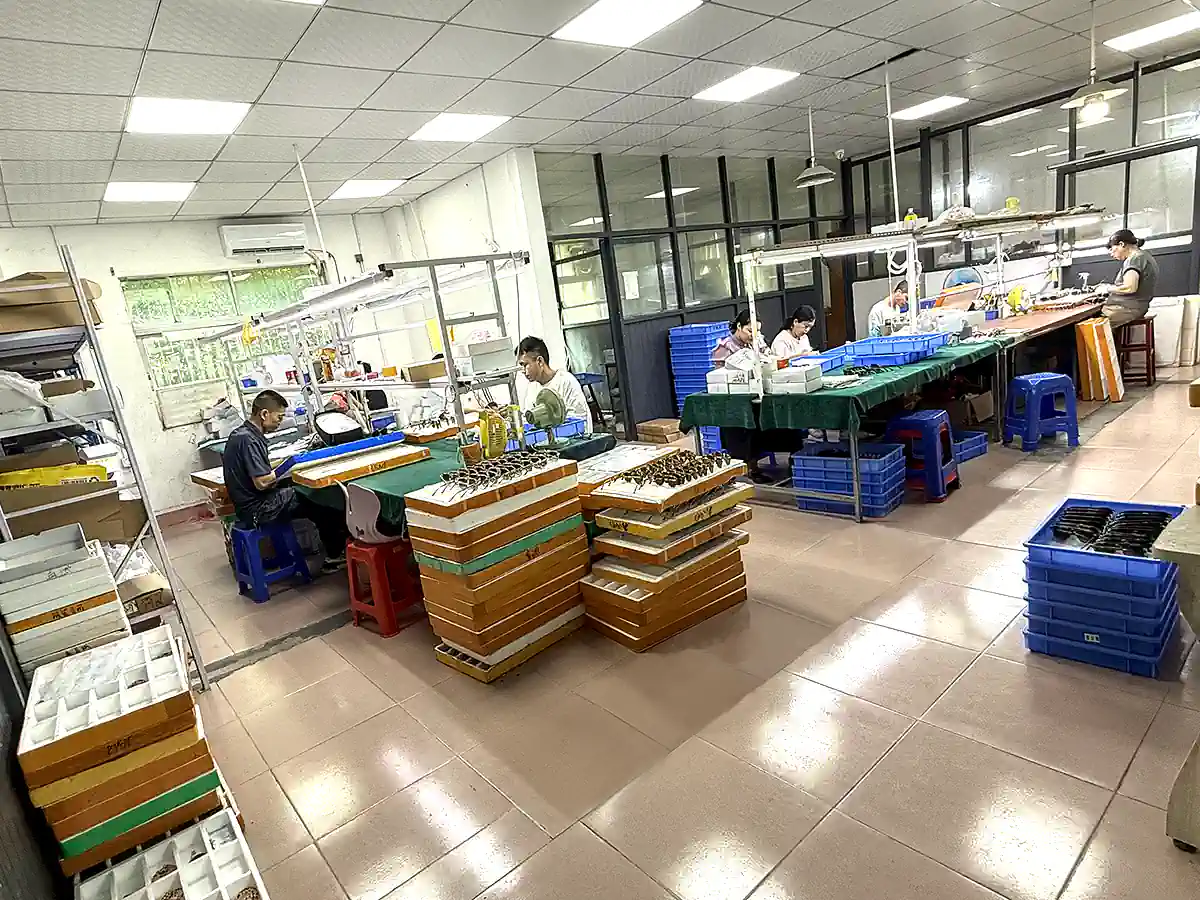Workers handling eyewear frames at assembly workstations in the SEESUN eyeglasses factory