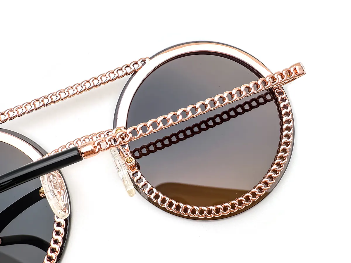 Rose-gold metal sunglasses with chain-style rim and temple detailing