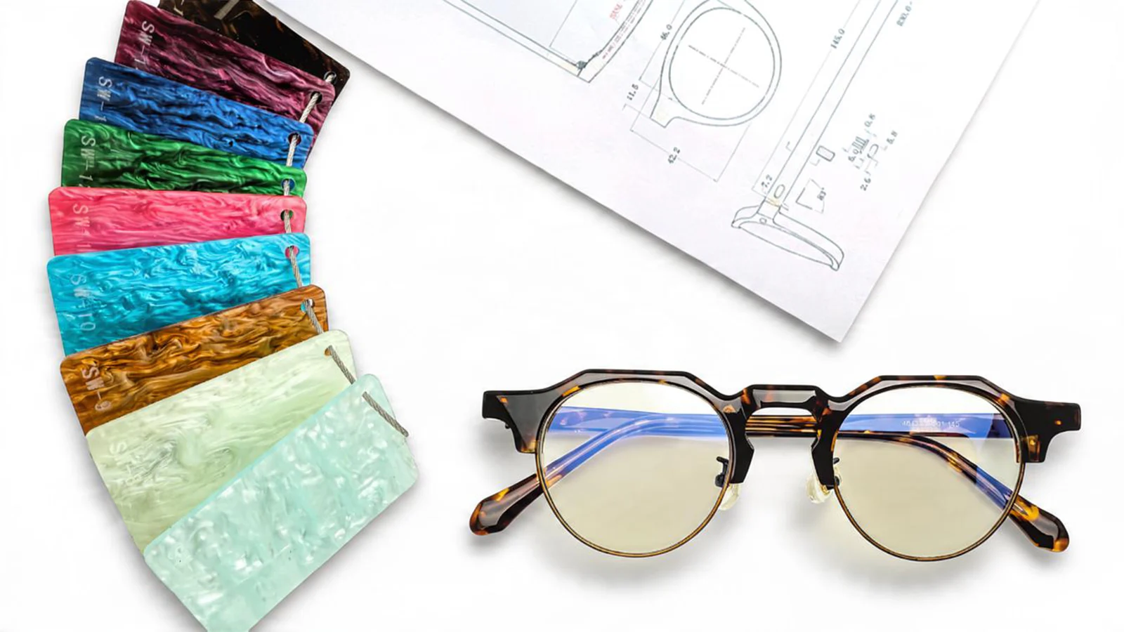 Tortoiseshell optical frame with colorful acetate samples and technical drawings for eyewear product development