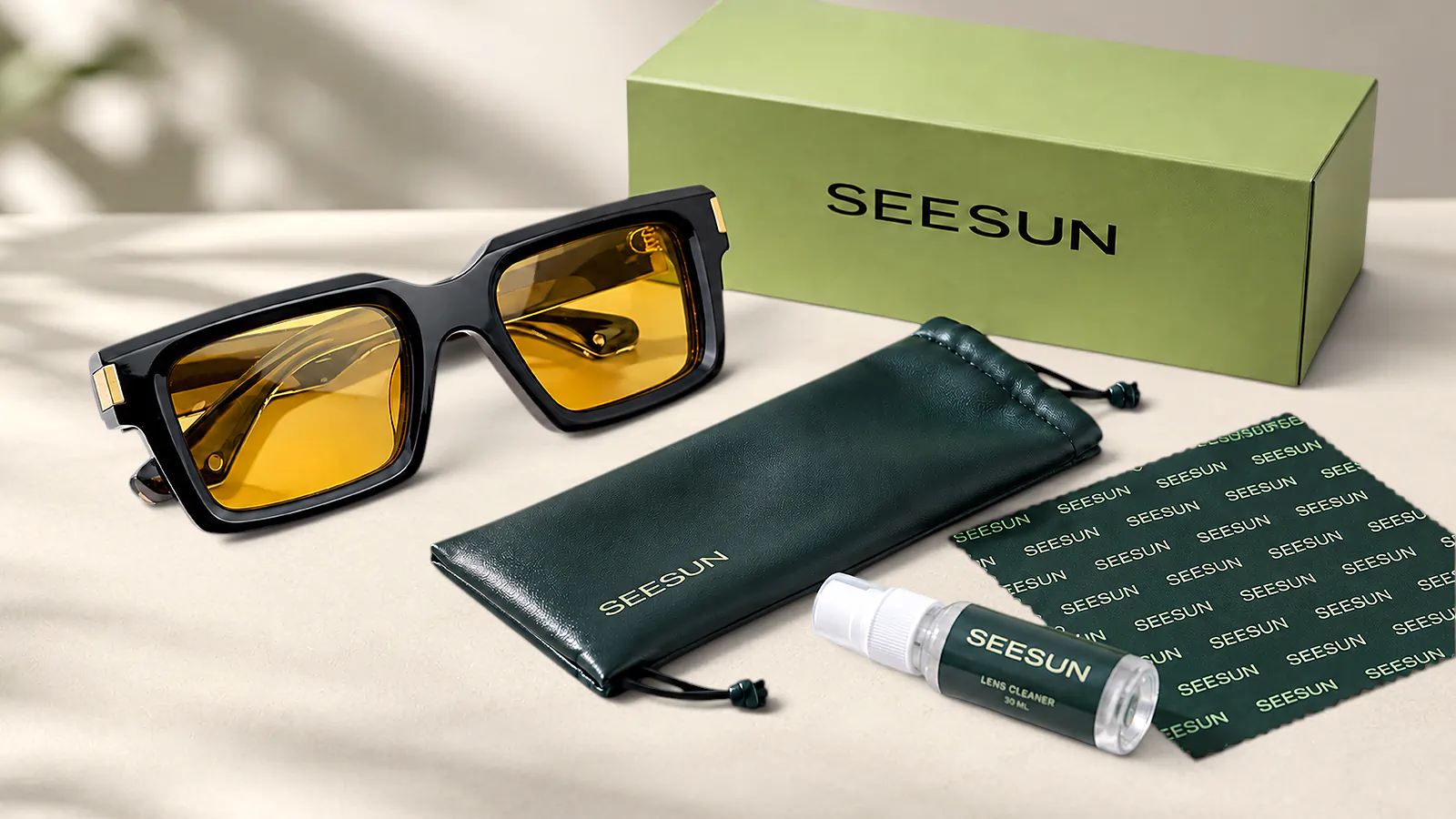 Black sunglasses with amber lenses beside a SEESUN-branded box, pouch, cleaning cloth and lens cleaner.